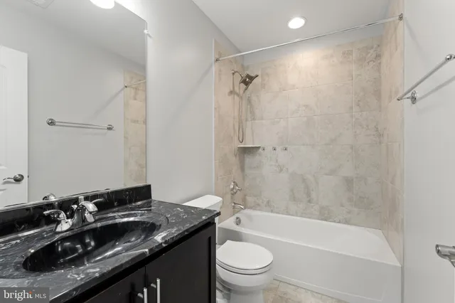 a bathroom with a granite countertop sink toilet and shower