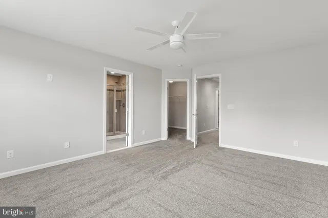 an empty room with closet and windows