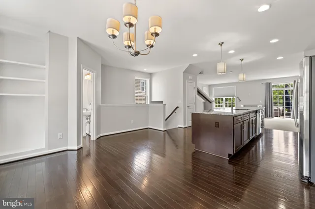 a living room with kitchen island furniture and a chandelier