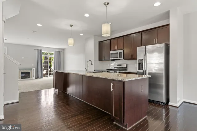 a kitchen with kitchen island white cabinets and refrigerator