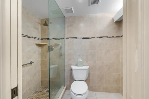 a bathroom with a toilet and a shower