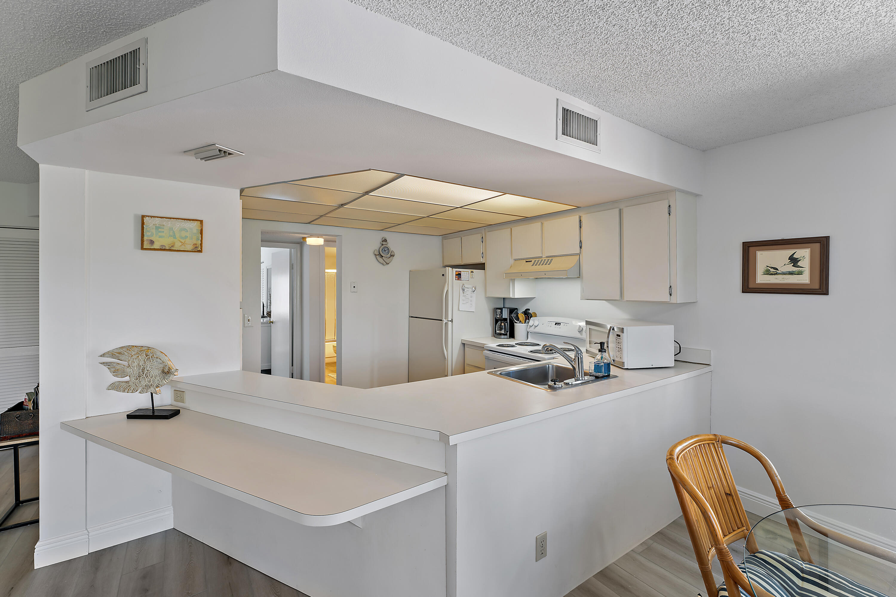 1605 Highway 1, Unit B201 Jupiter, FL 33477 - Photo 14 of 33 a kitchen with stainless steel appliances a sink cabinets and wooden floor