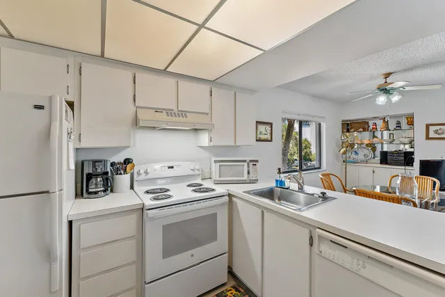 a kitchen with stainless steel appliances white cabinets and a stove top oven