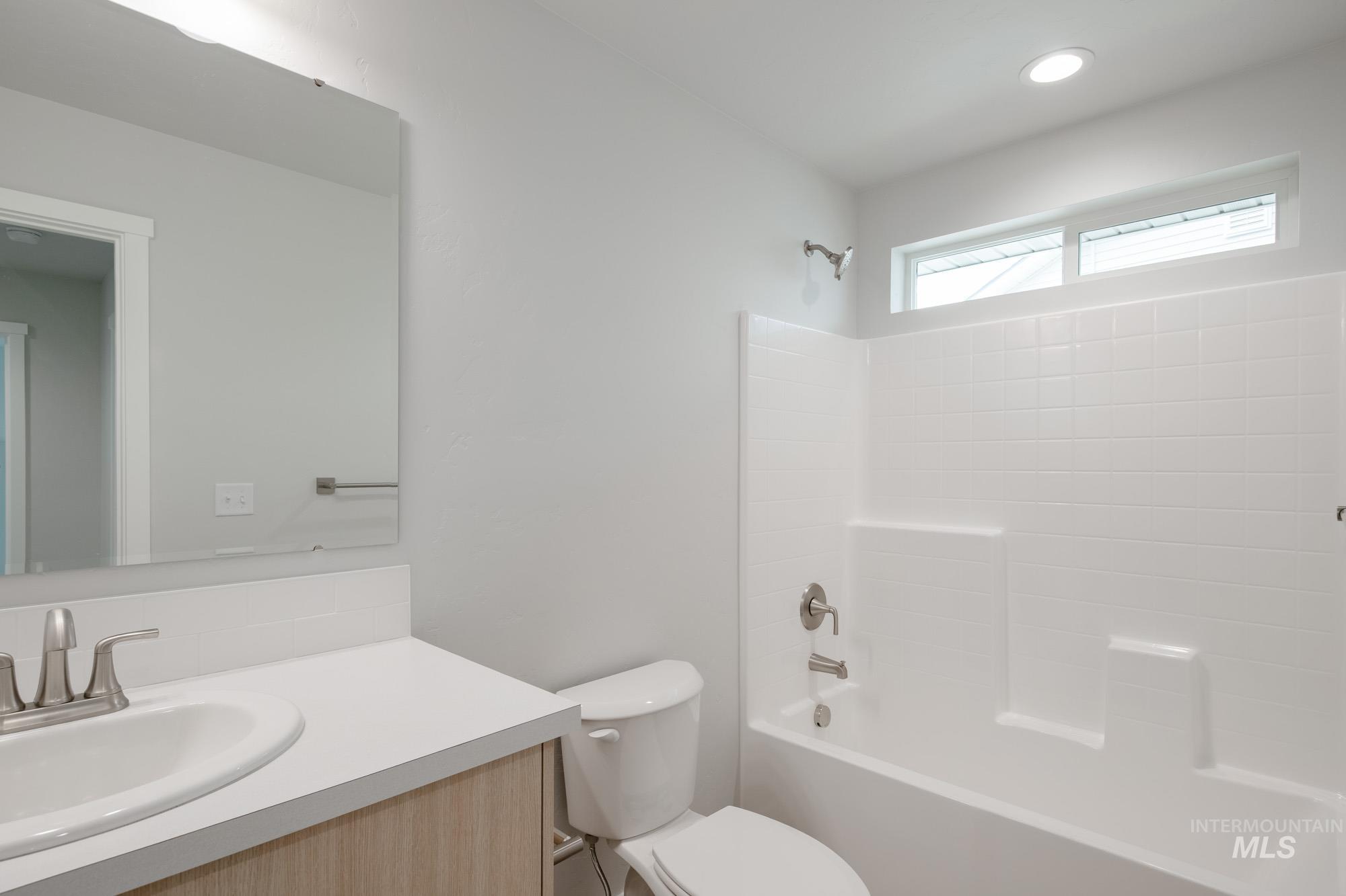 2391 West Fallon Loop Nampa, ID 83651 - Photo 14 of 20 Bathroom featuring a white vanity with a rectangular undermount sink, brushed nickel faucet, and light wood-finish cabinetry