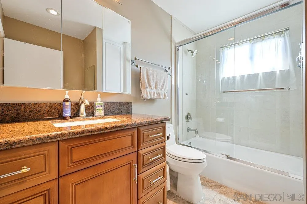 6780 Mission Gorge Road, Unit 12 San Diego, CA 92120 - Photo 12 of 23 a bathroom with a granite countertop sink toilet and shower