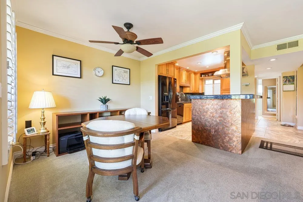 6780 Mission Gorge Road, Unit 12 San Diego, CA 92120 - Photo 3 of 23 a dining room with furniture and a chandelier