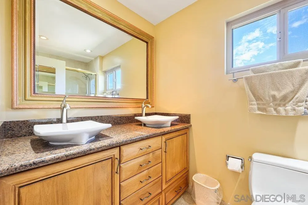 6780 Mission Gorge Road, Unit 12 San Diego, CA 92120 - Photo 9 of 23 a bathroom with a granite countertop sink mirror vanity and toilet