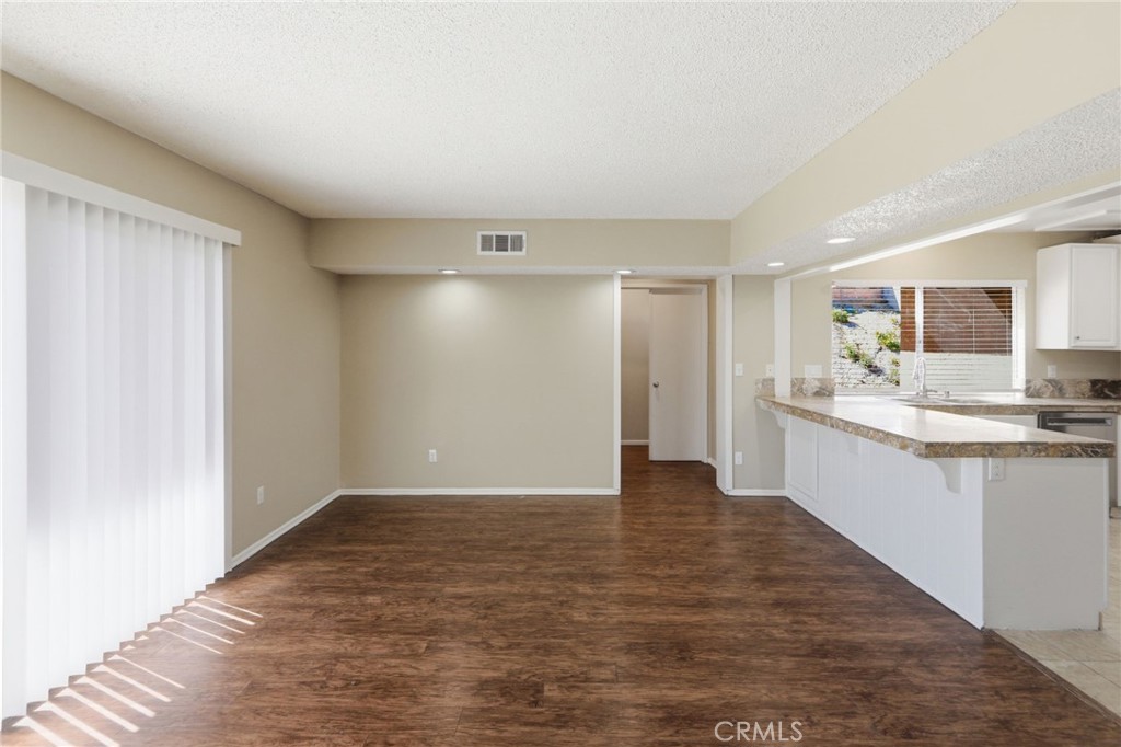 1420 Timberlane Drive Riverside, CA 92506 - Photo 12 of 61 a view of a kitchen with a sink and dishwasher a kitchen island with wooden floor