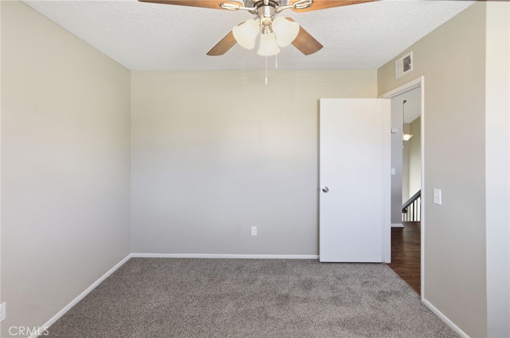 1420 Timberlane Drive Riverside, CA 92506 - Photo 26 of 61 an empty room with a ceiling fan and carpet