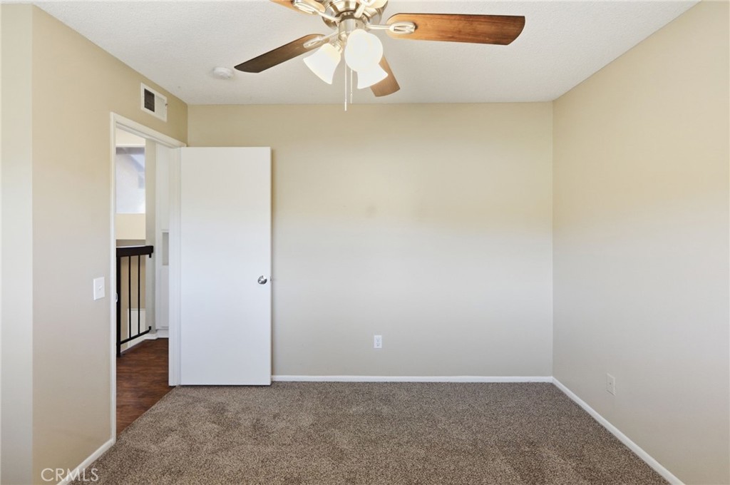 1420 Timberlane Drive Riverside, CA 92506 - Photo 30 of 61 an empty room with a ceiling fan and carpet