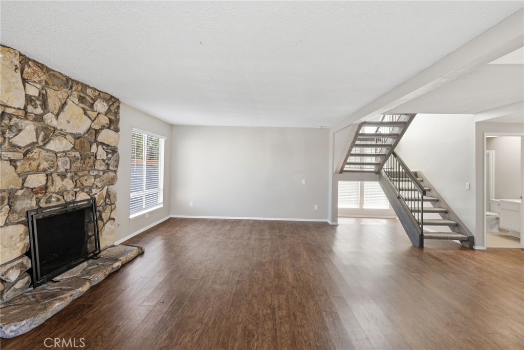 1420 Timberlane Drive Riverside, CA 92506 - Photo 7 of 61 an empty room with wooden floor fireplace and windows