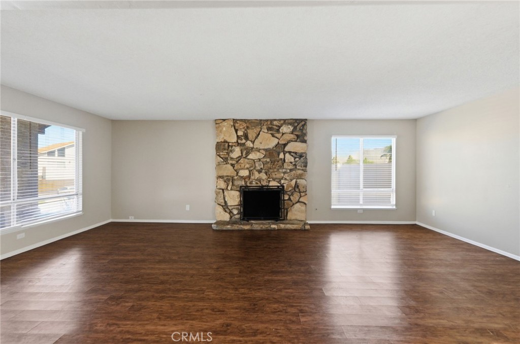 1420 Timberlane Drive Riverside, CA 92506 - Photo 9 of 61 an empty room with wooden floor fireplace and windows