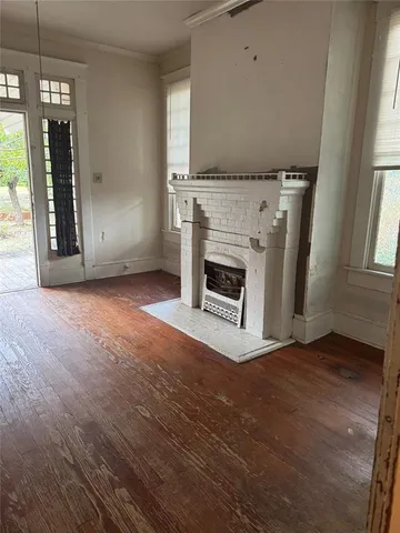 an empty room with windows and fireplace