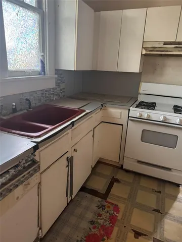 a kitchen with a stove cabinets and a sink