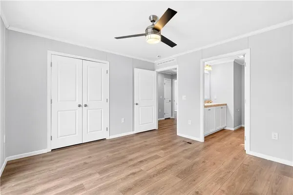 a view of empty room with wooden floor and ceiling fan