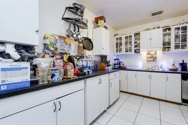 a kitchen with granite countertop white cabinets and white appliances