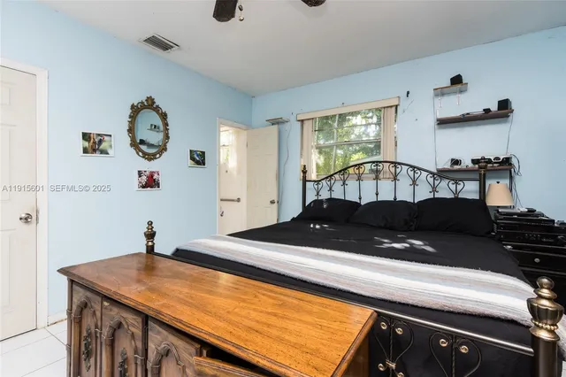 a bed sitting in a bedroom next to a window