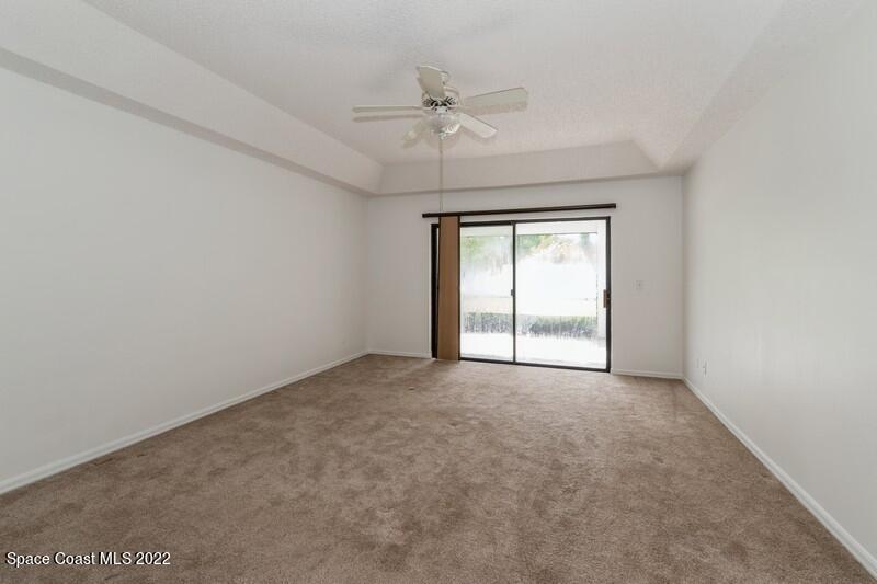 711 Montclair Road Northeast Palm Bay, FL 32905 - Photo 16 of 35 an empty room with a ceiling fan and a window