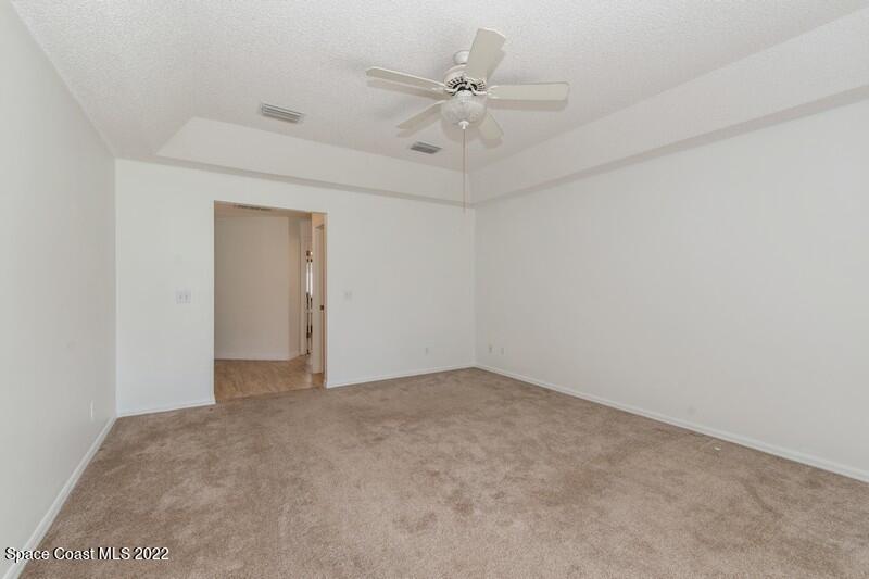 711 Montclair Road Northeast Palm Bay, FL 32905 - Photo 18 of 35 an empty room with a ceiling fan and a window