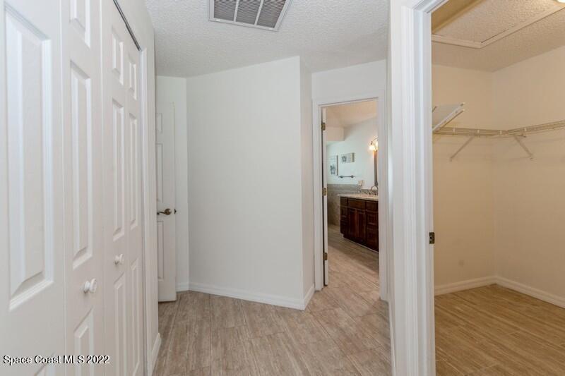 711 Montclair Road Northeast Palm Bay, FL 32905 - Photo 20 of 35 a view of a hallway with wooden floor and a bathroom