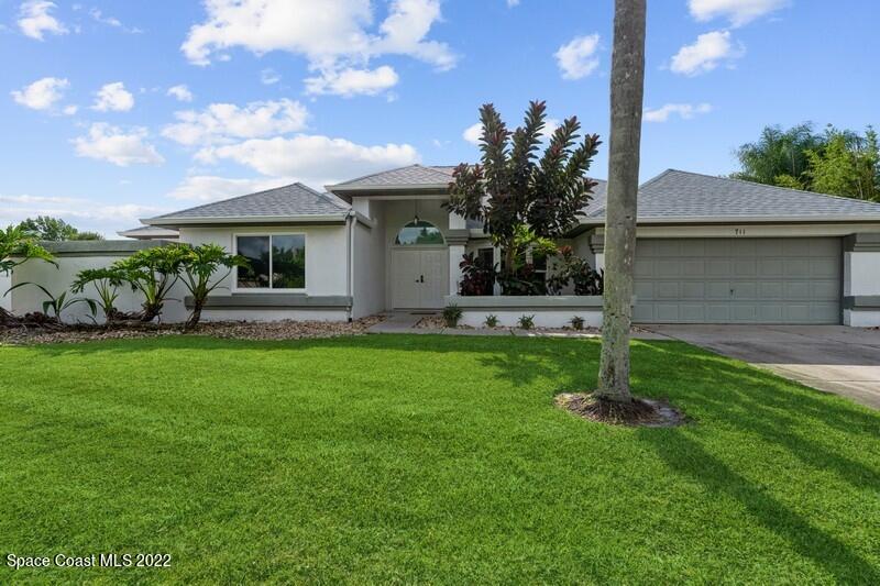 711 Montclair Road Northeast Palm Bay, FL 32905 - Photo 2 of 35 a front view of a house with garden