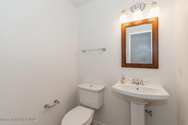711 Montclair Road Northeast Palm Bay, FL 32905 - Photo 27 of 35 a bathroom with a sink mirror and toilet