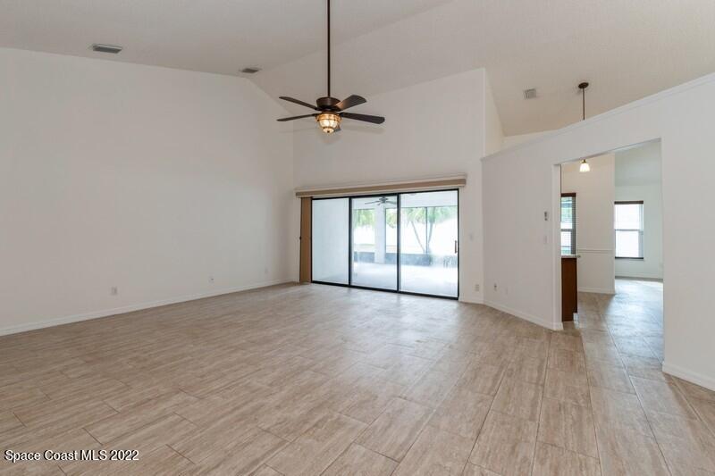 711 Montclair Road Northeast Palm Bay, FL 32905 - Photo 3 of 35 a view of an empty room with a window and wooden floor