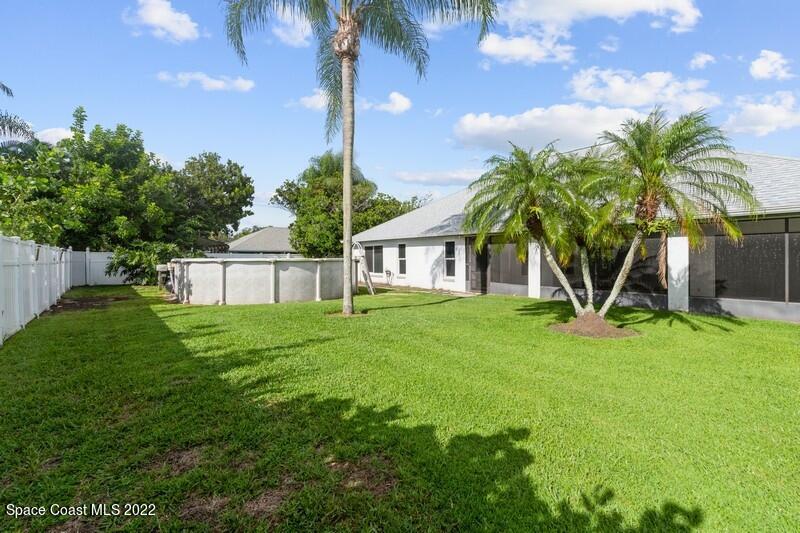 711 Montclair Road Northeast Palm Bay, FL 32905 - Photo 31 of 35 a view of a house with a yard and palm trees