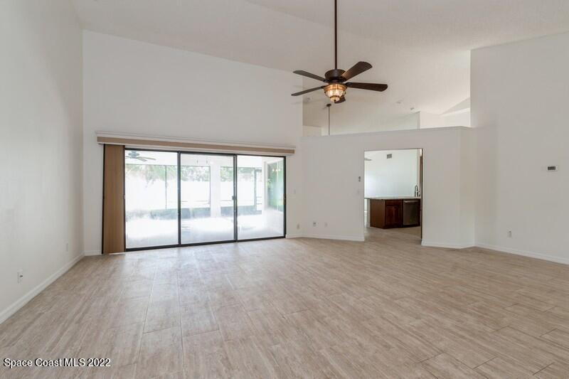 711 Montclair Road Northeast Palm Bay, FL 32905 - Photo 4 of 35 wooden floor in an empty room with a window