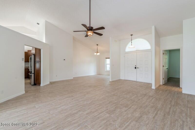 711 Montclair Road Northeast Palm Bay, FL 32905 - Photo 5 of 35 a view of a room with an empty space and a ceiling fan