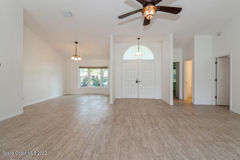 711 Montclair Road Northeast Palm Bay, FL 32905 - Photo 6 of 35 wooden floor in an empty room with a window