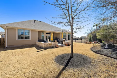 a backyard of a house with yard and tree