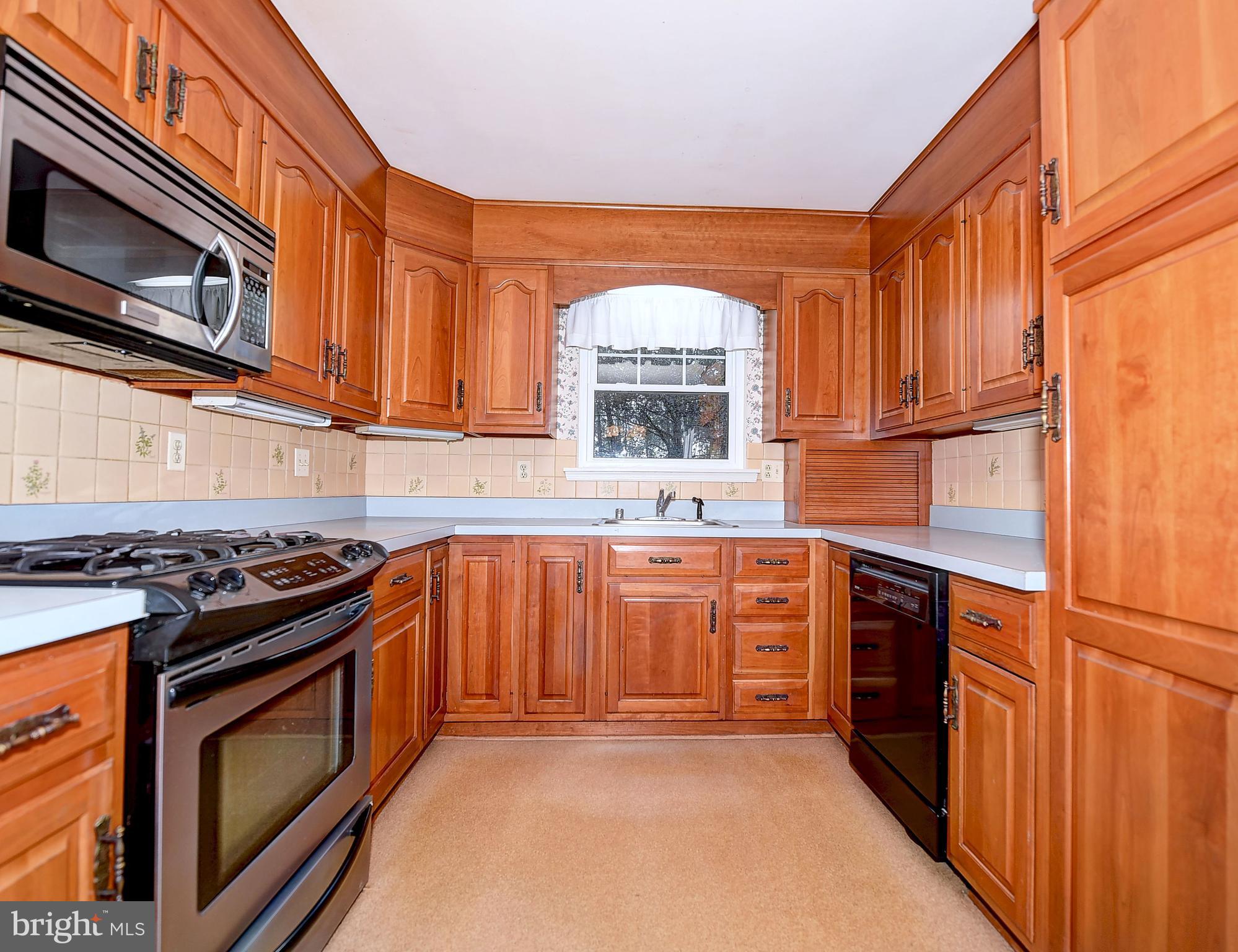 9200 Dogwood Road Baltimore, MD 21244 - Photo 4 of 25 a kitchen with stainless steel appliances granite countertop a stove a sink and a microwave
