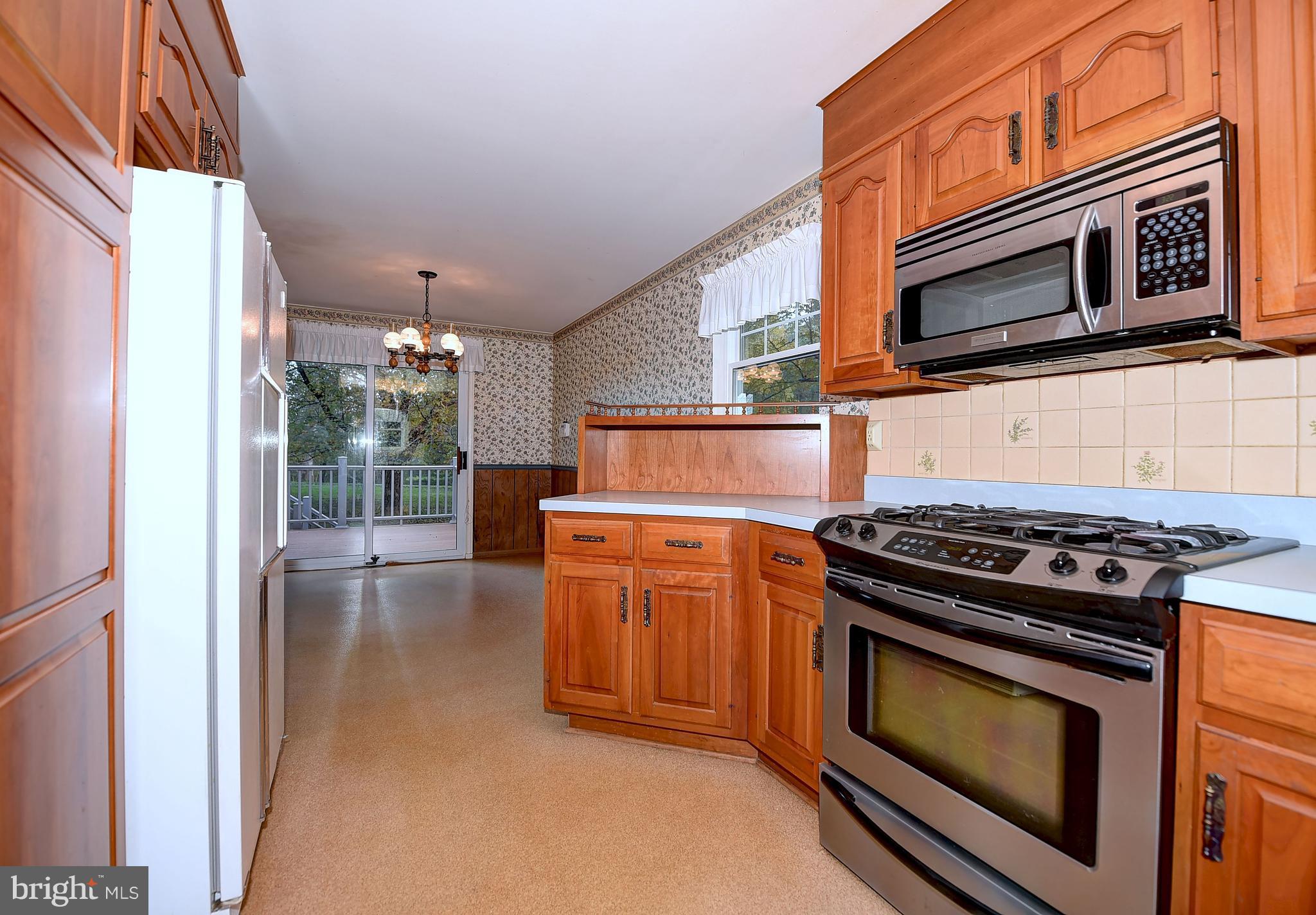 9200 Dogwood Road Baltimore, MD 21244 - Photo 5 of 25 a kitchen with stainless steel appliances a stove a microwave and cabinets