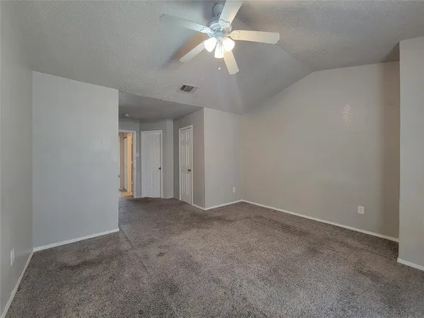 a view of an empty room with a ceiling fan and a window