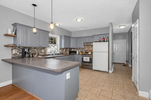 a kitchen with sink refrigerator and cabinets