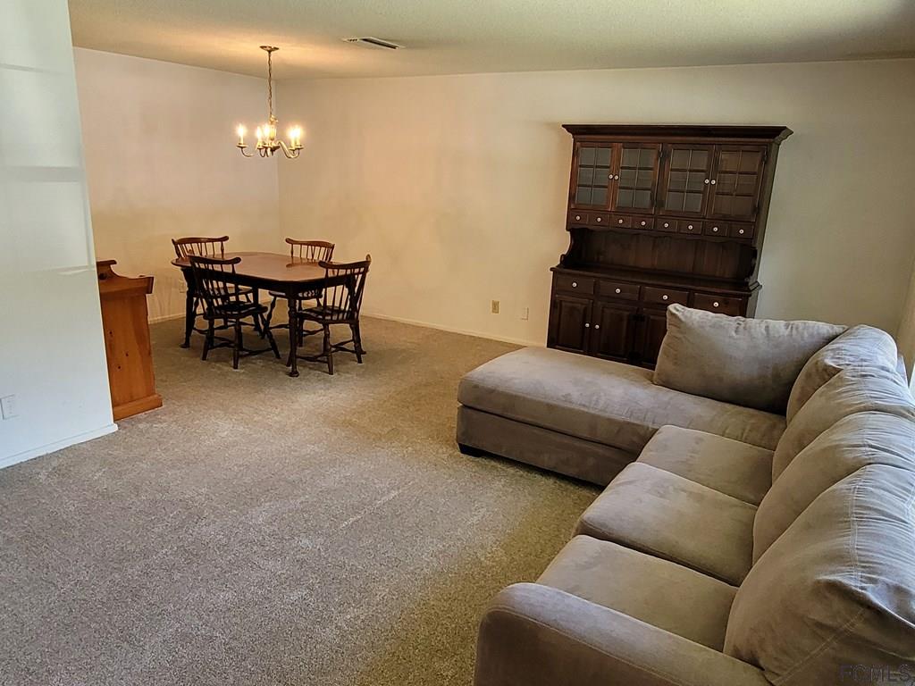 736 Lindenwood Circle Ormond Beach, FL 32174 - Photo 12 of 56 a living room with furniture and a lamp