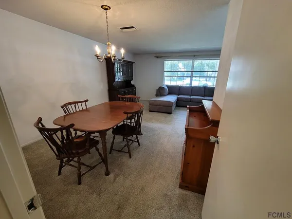 a view of a dining room with furniture and chandelier