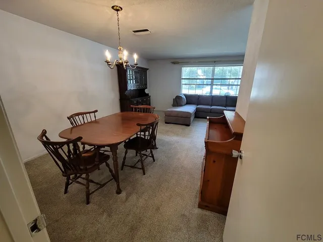 a view of a dining room with furniture and chandelier
