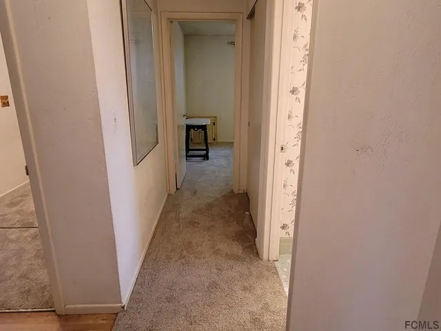 an empty room with windows and ceiling fan view