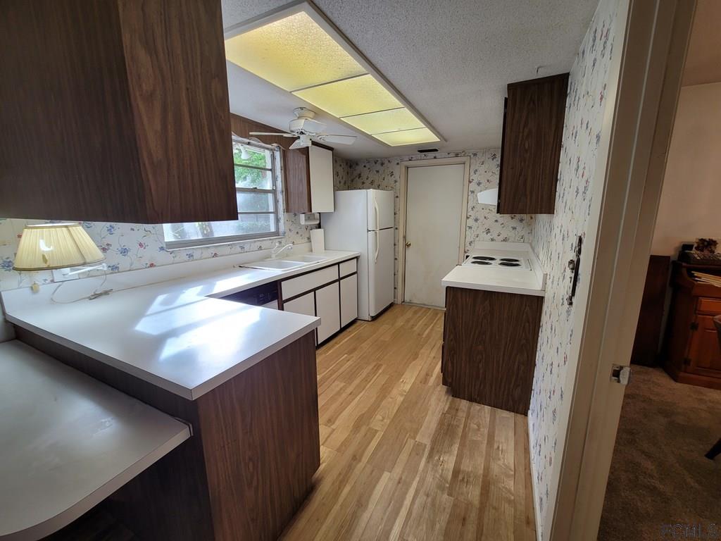 736 Lindenwood Circle Ormond Beach, FL 32174 - Photo 43 of 56 a kitchen with stainless steel appliances cabinets a sink and a large window
