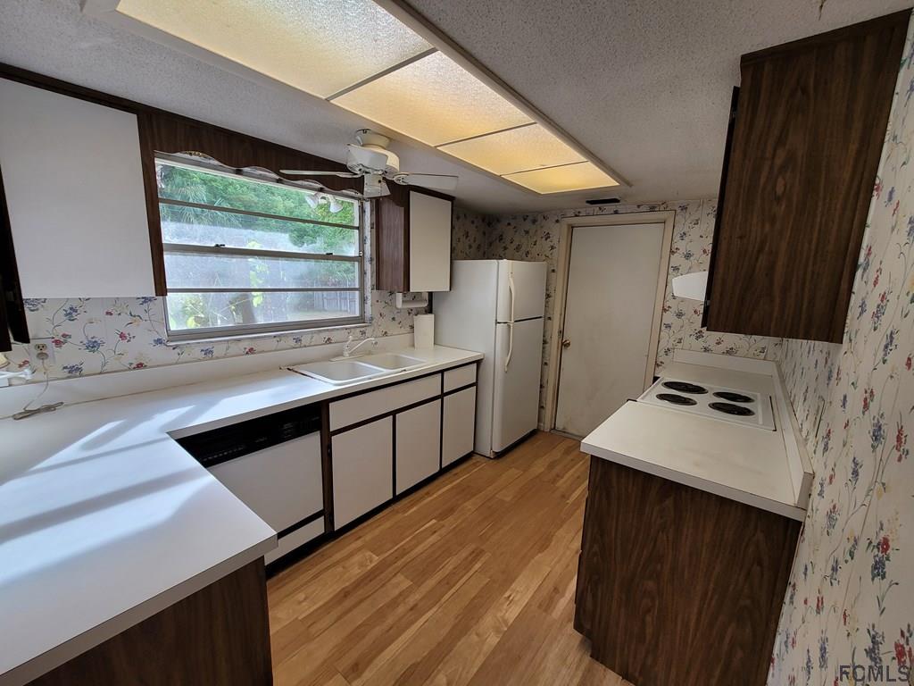 736 Lindenwood Circle Ormond Beach, FL 32174 - Photo 44 of 56 a kitchen with a sink stove and refrigerator