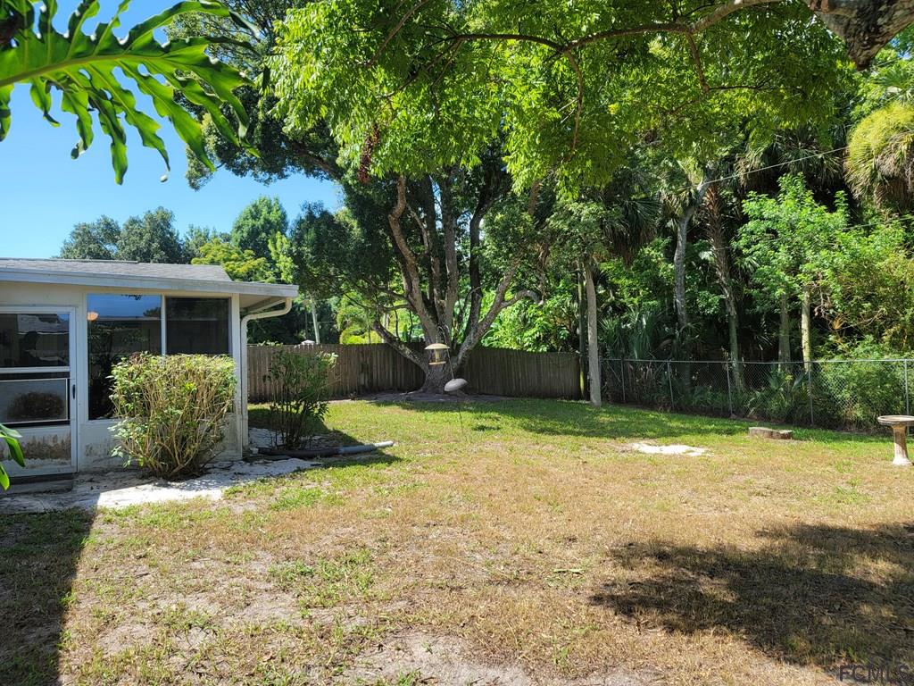 736 Lindenwood Circle Ormond Beach, FL 32174 - Photo 53 of 56 a backyard of a house with a swing and plants