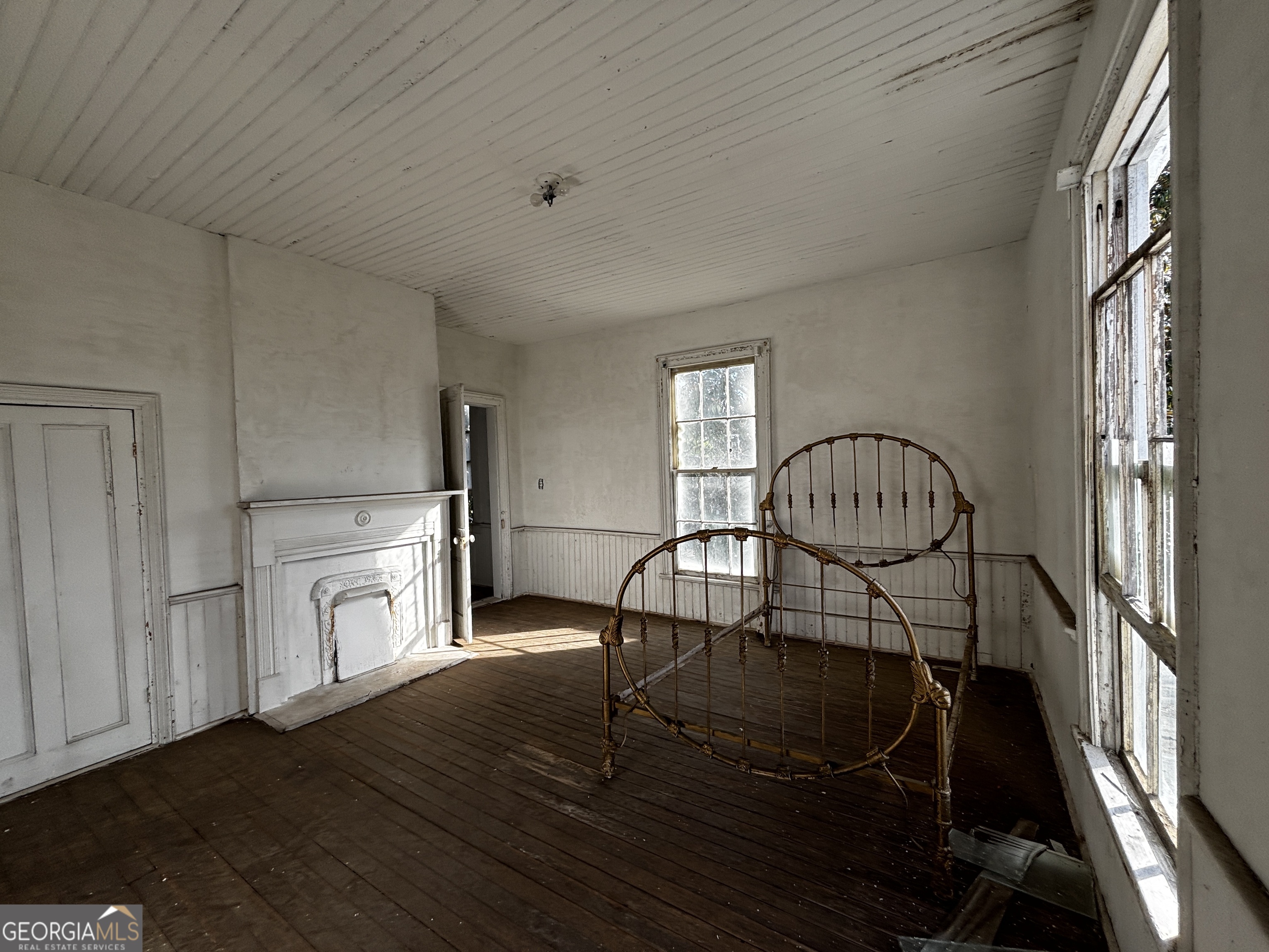 301 Cleveland Street Thomson, GA 30824 - Photo 12 of 17 a view of a livingroom with furniture a fireplace wooden floor and windows
