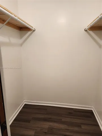 a view of a small space with wooden floor and a window