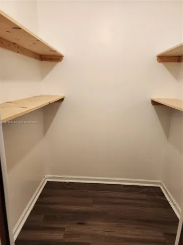 a view of a small space with wooden floor and a window