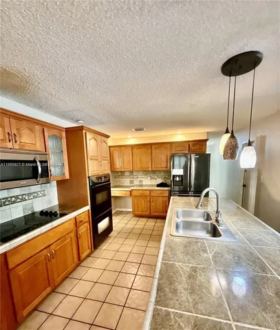 a kitchen with stainless steel appliances kitchen island granite countertop a sink and cabinets