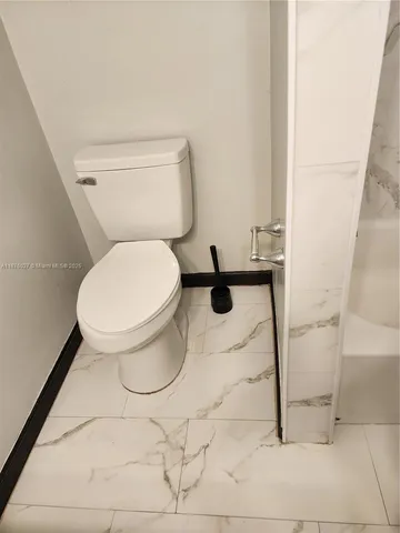 a white toilet sitting next to a white sink