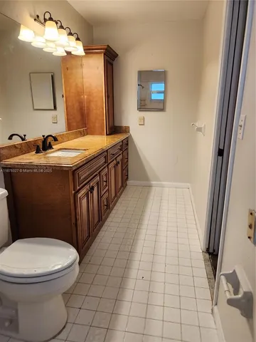 a bathroom with a sink a toilet and mirror