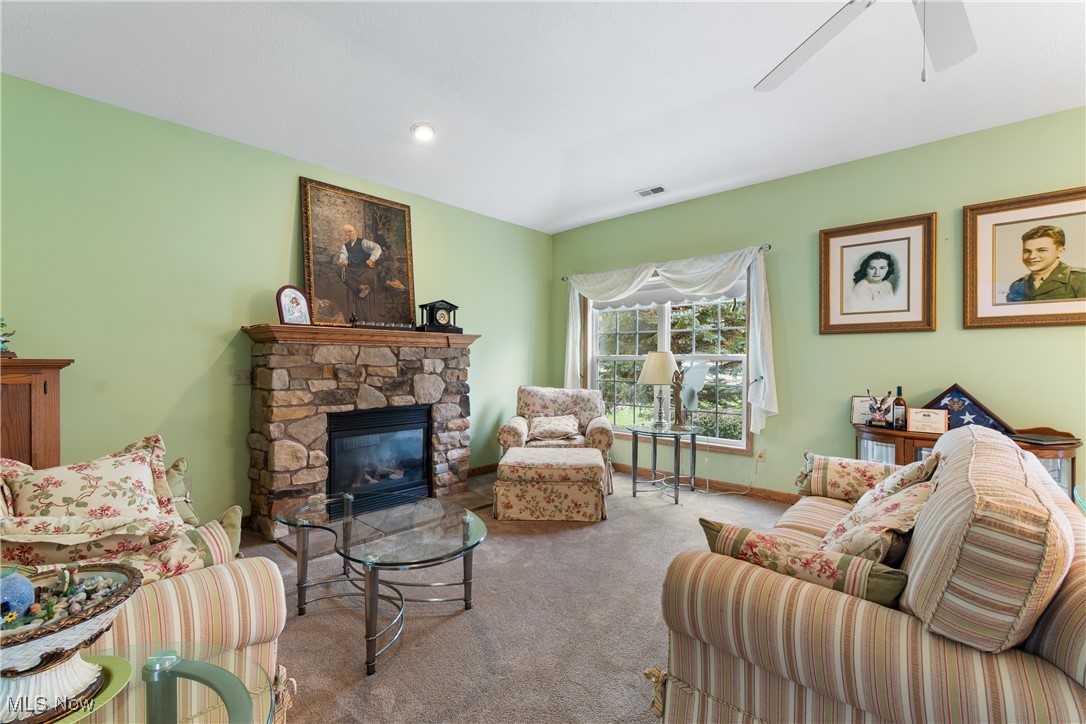 7030 Knight Avenue Northwest Canton, OH 44708 - Photo 4 of 26 Carpeted living room with a fireplace and ceiling fan